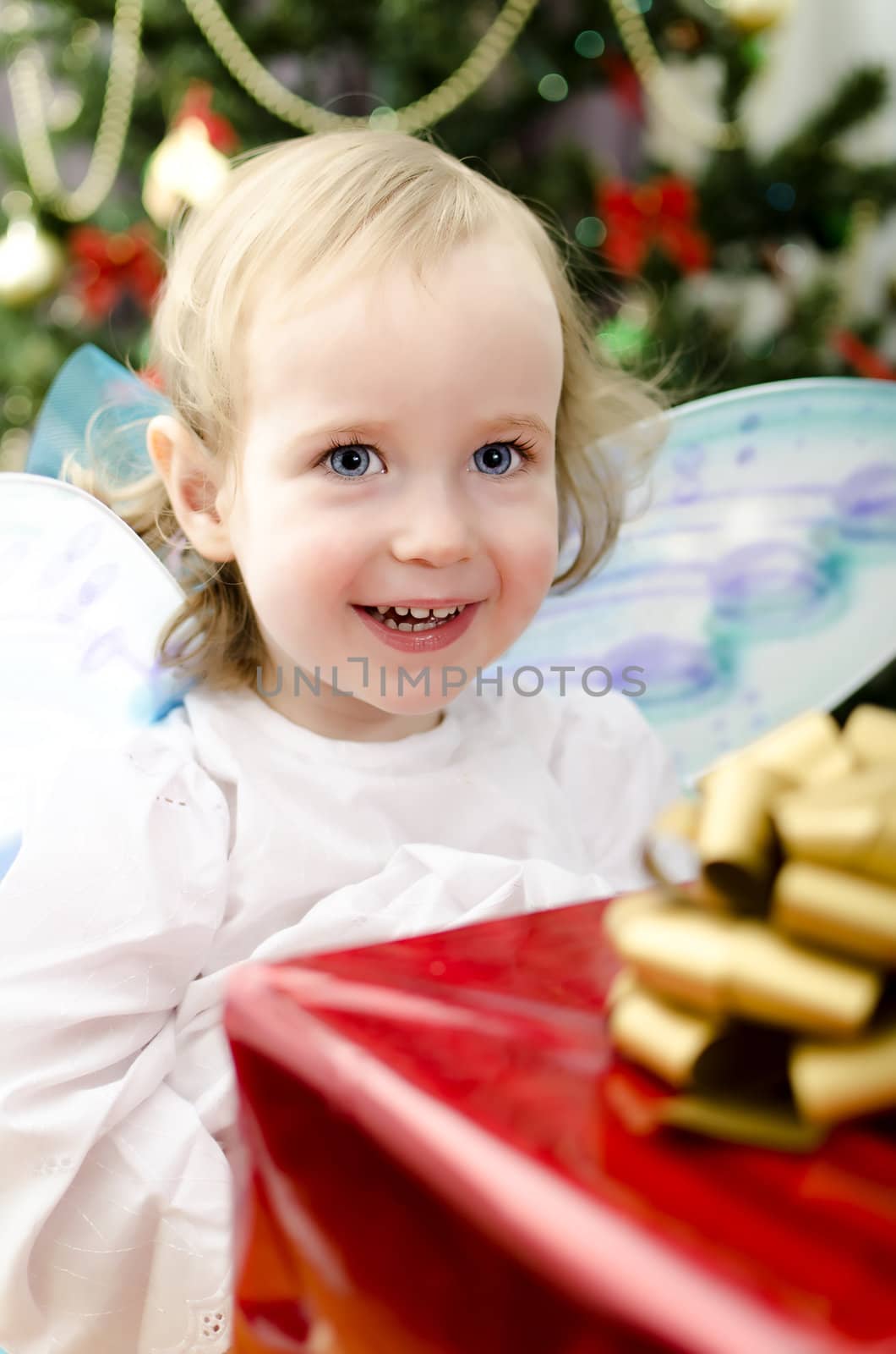 little girl smiling with christmas gift in hand