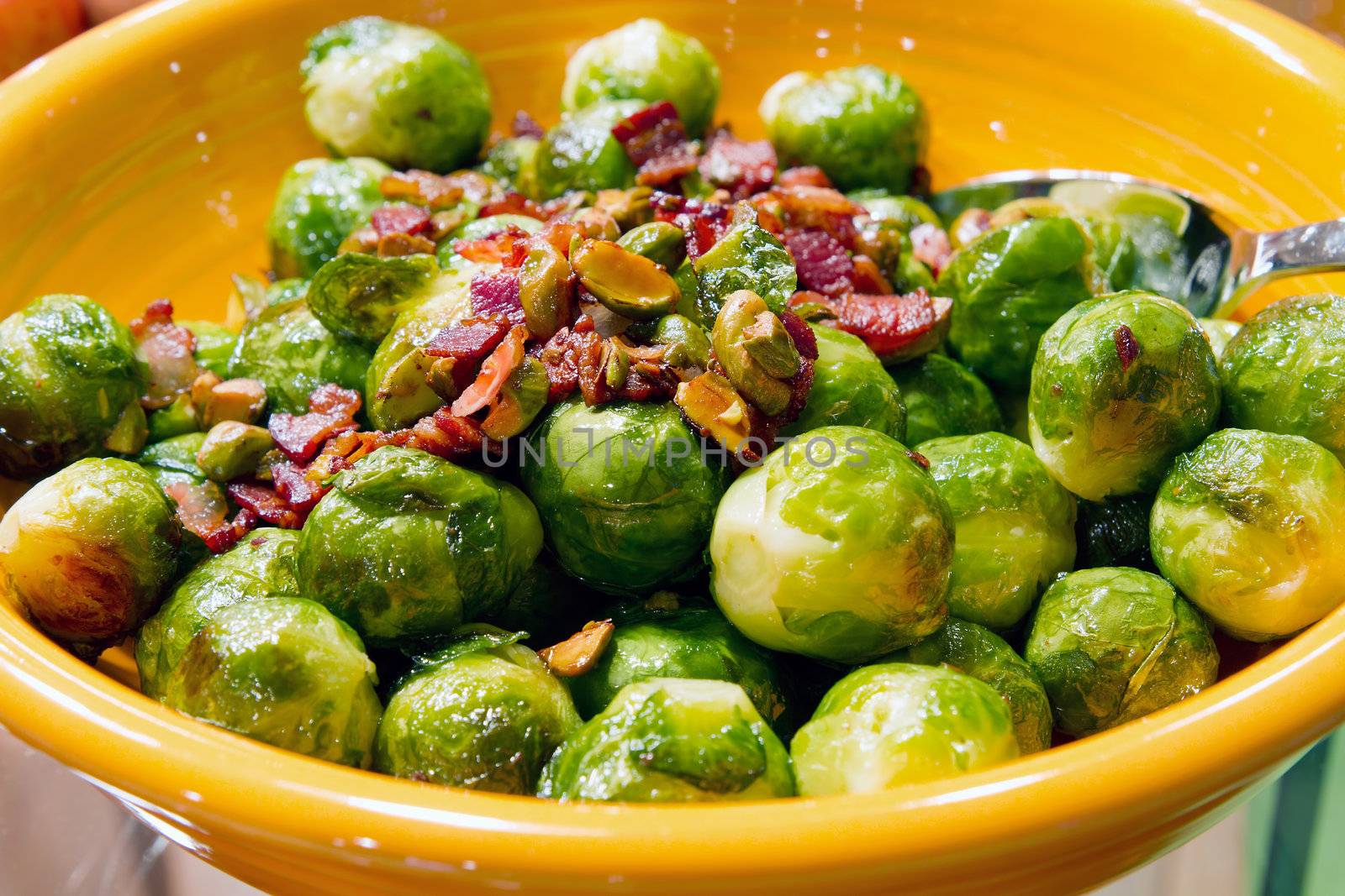 Thanksgiving Day Dinner Brussels Sprouts Dish with Bacon Bits and Pistachios Nuts Closeup