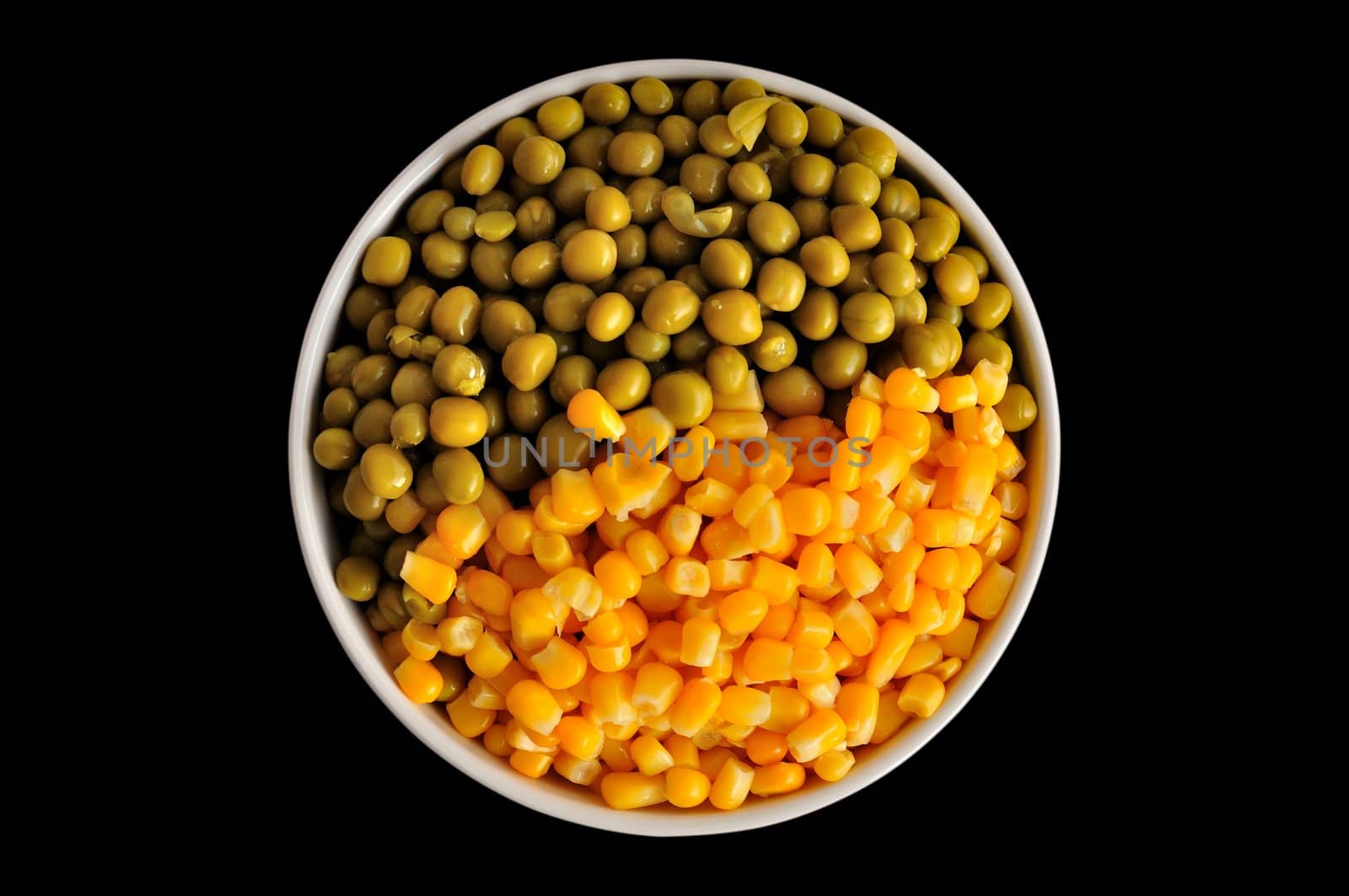 a plate with corn and peas, isolated, on a black background