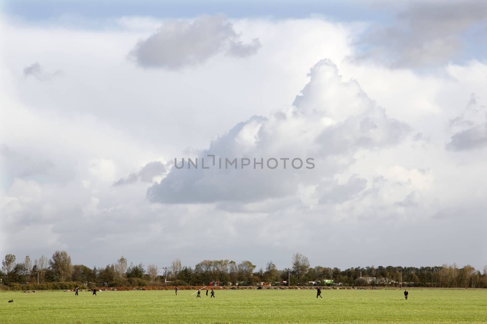 hunters in a meadow in the Netherlands under a cloudy sky