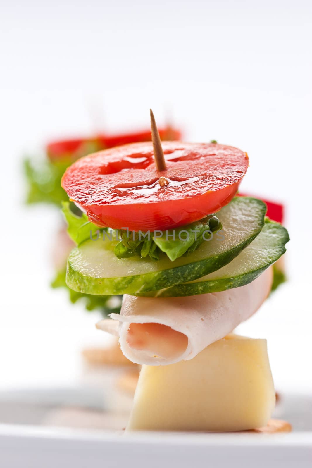 food theme: cracker with ham, cheese and vegetables on the plate