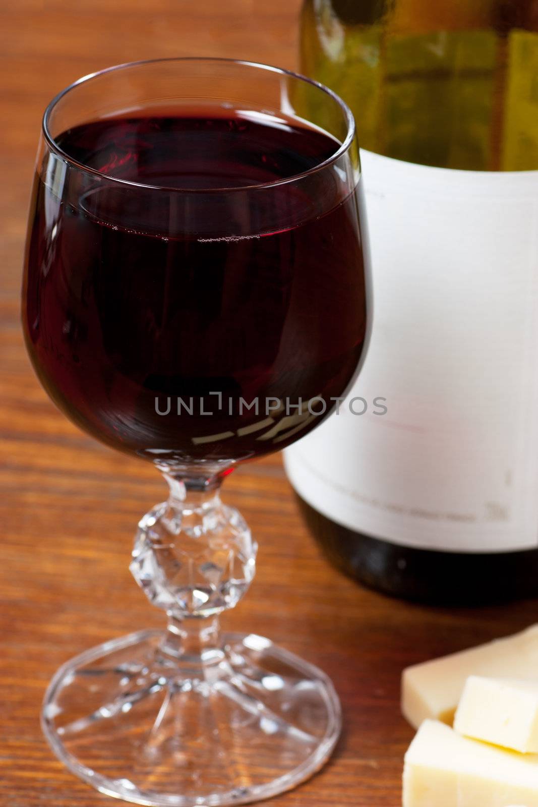 Wine glass and bottle and cheese on a table