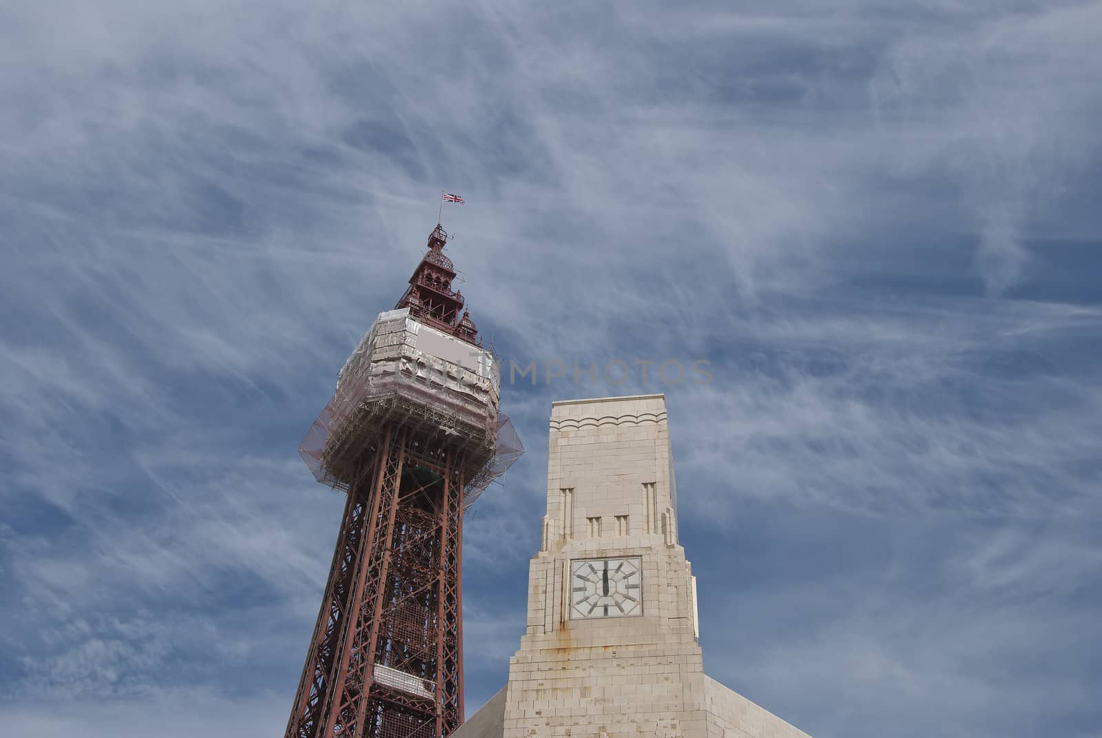 The Famous Tower at Blackpool alongside an art deco clocktowerunder a cloudy sky