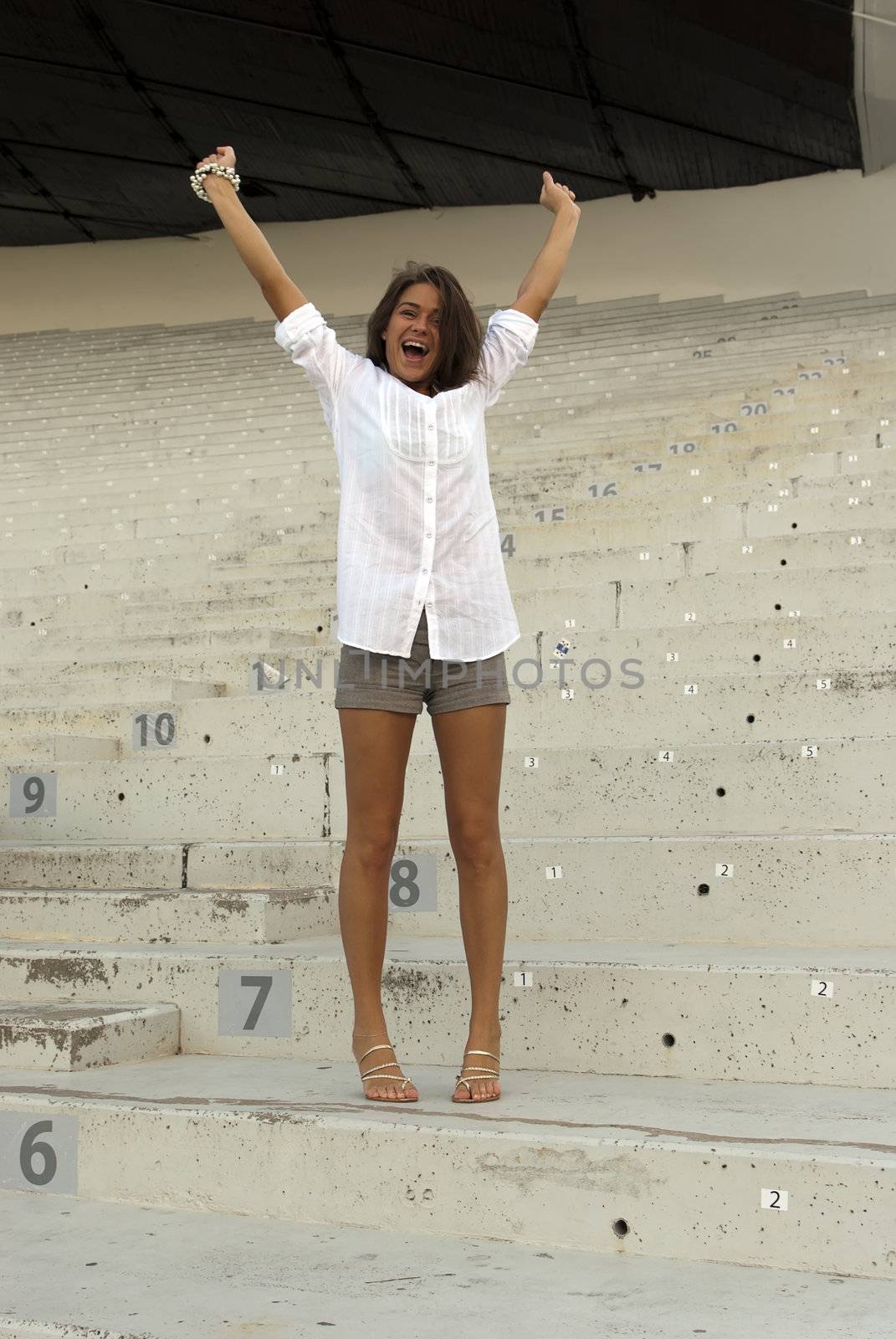 Beautiful girl jumping in an empty stadium by dmitrimaruta