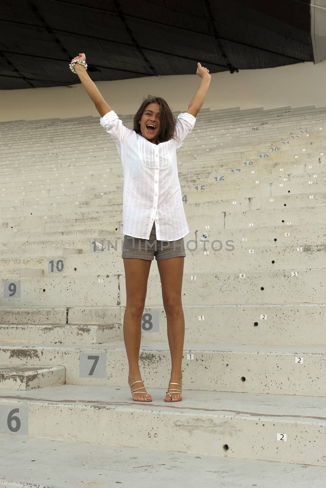 Beautiful girl jumping in an empty stadium