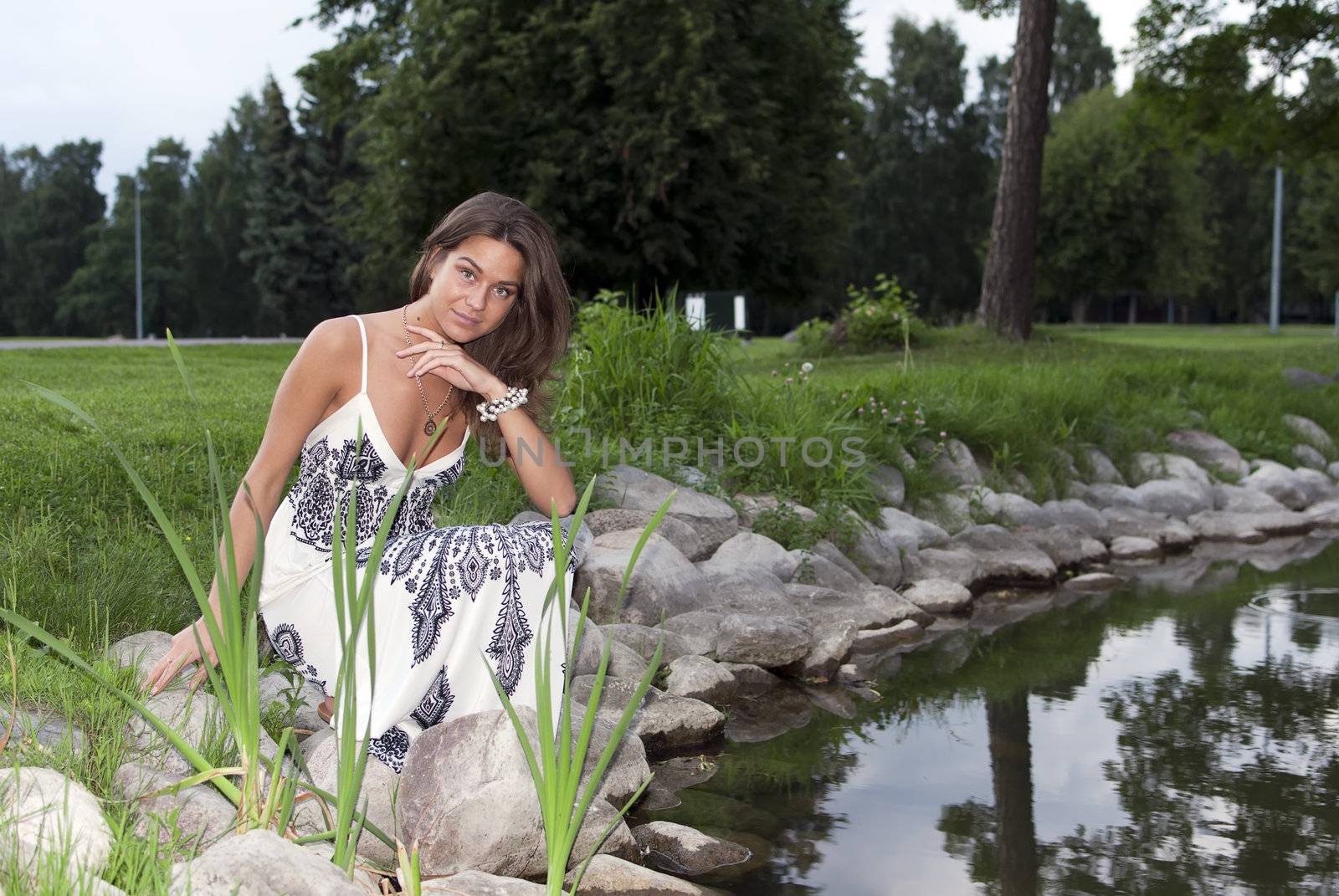 Girl sitting on the edge of the pond by dmitrimaruta