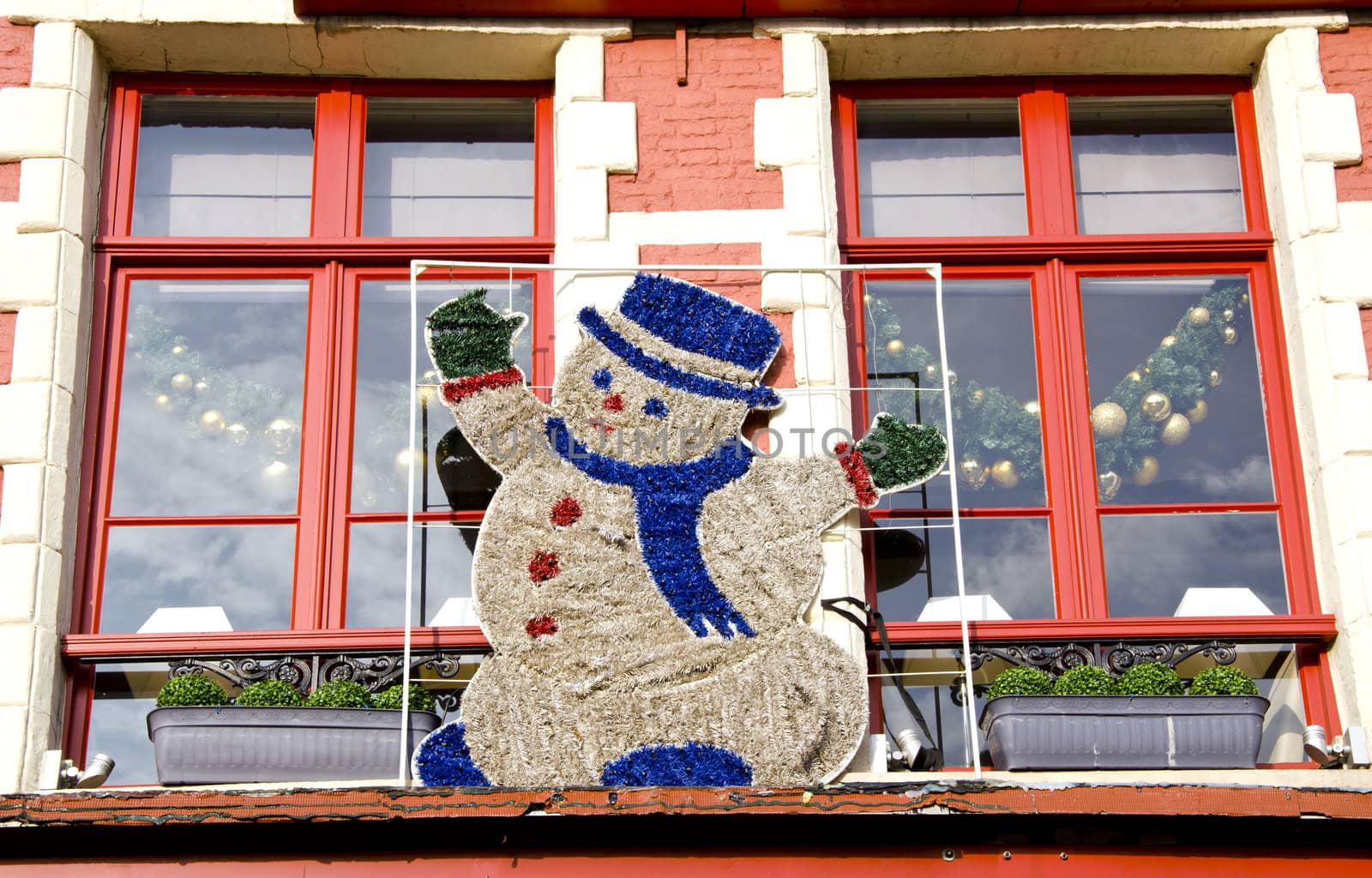 Snowman on the old town window in Belgium