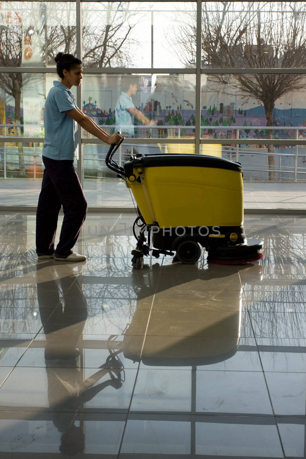 A worker is cleaning the floor with equipment