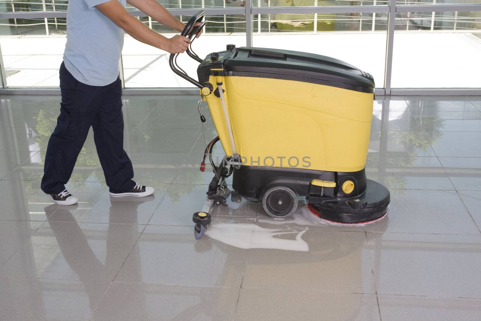 A worker is cleaning the floor with equipment