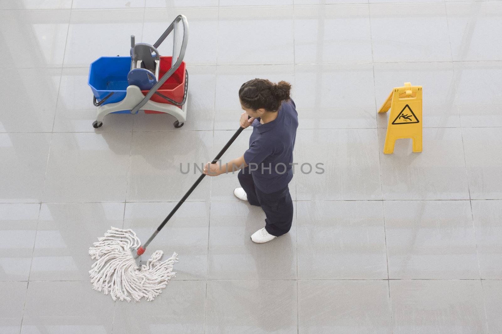 A worker is cleaning the floor with equipment