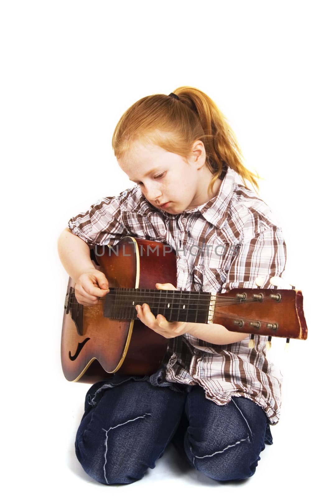 little girl playing on a guitar