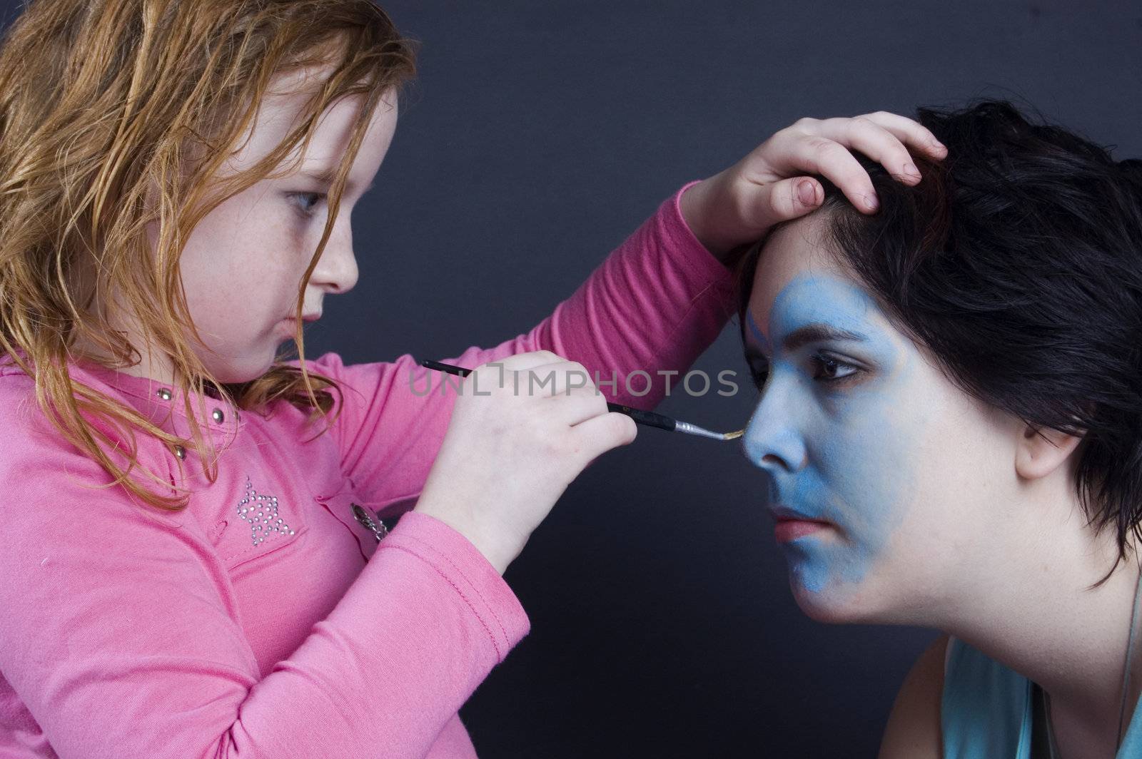 young girl is painting females face by ladyminnie