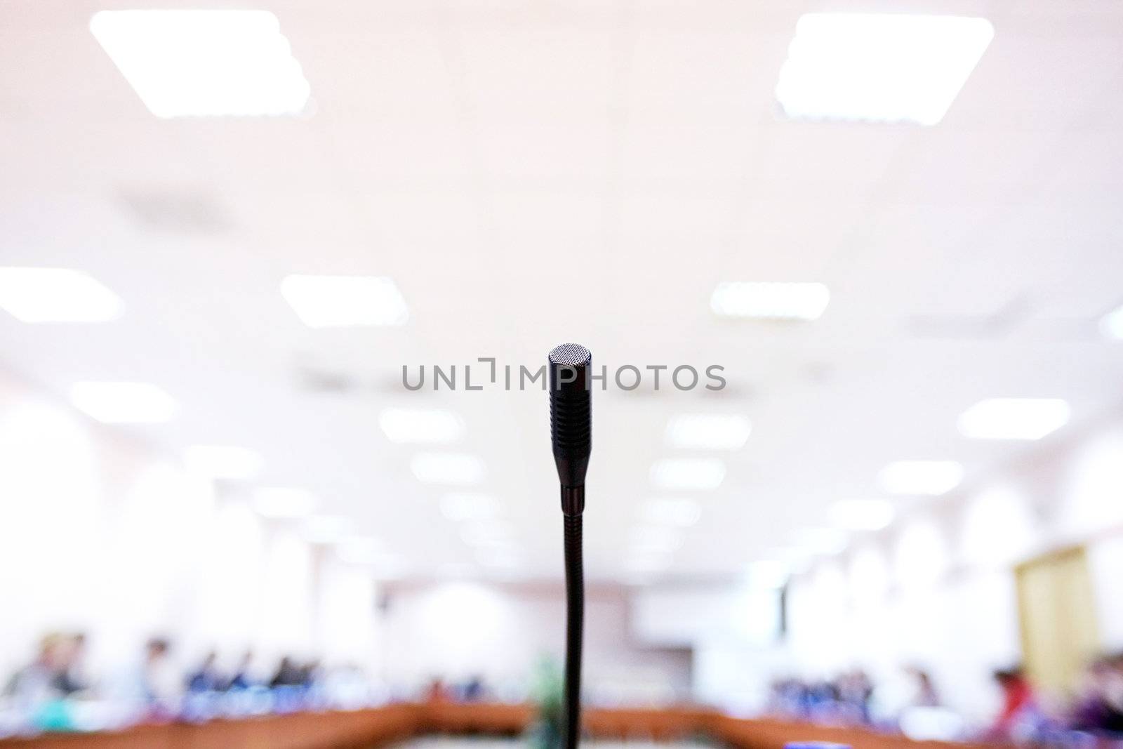 microphone in a big conference hall with numerous chairs.