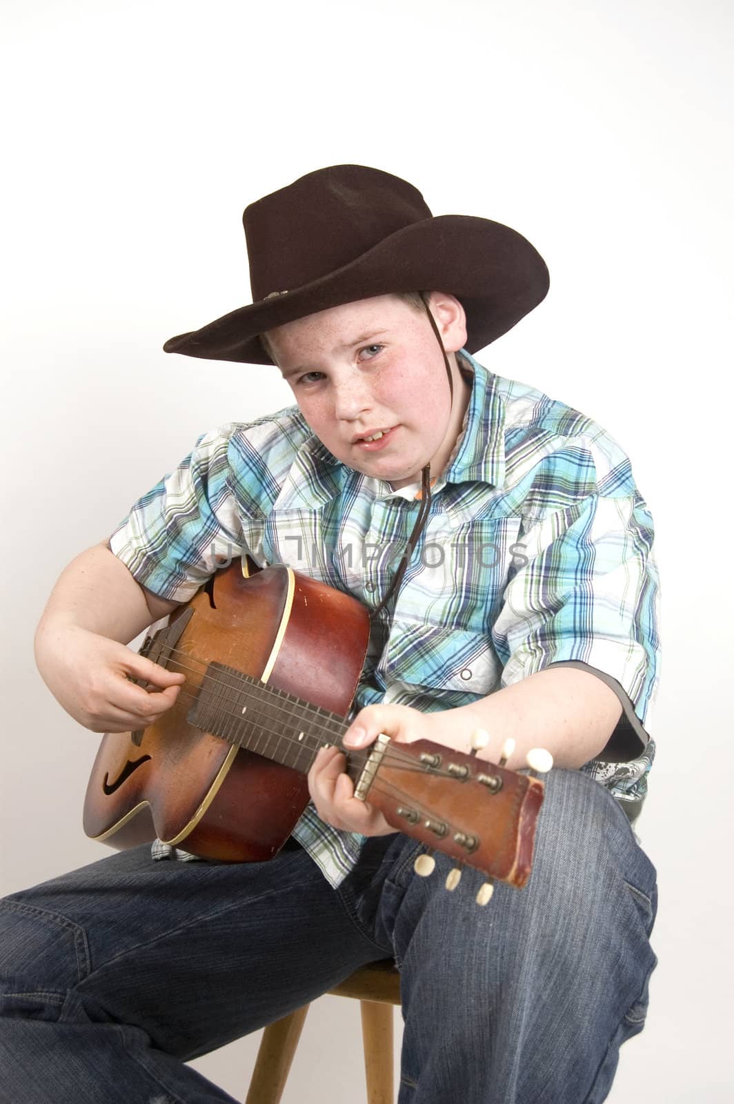 young handsome cowboy playing the guitar by ladyminnie