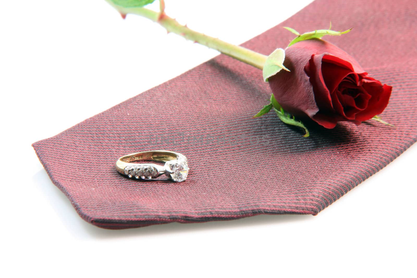 wedding proposal equipment diomond ring, red silk tie and red rose on white background