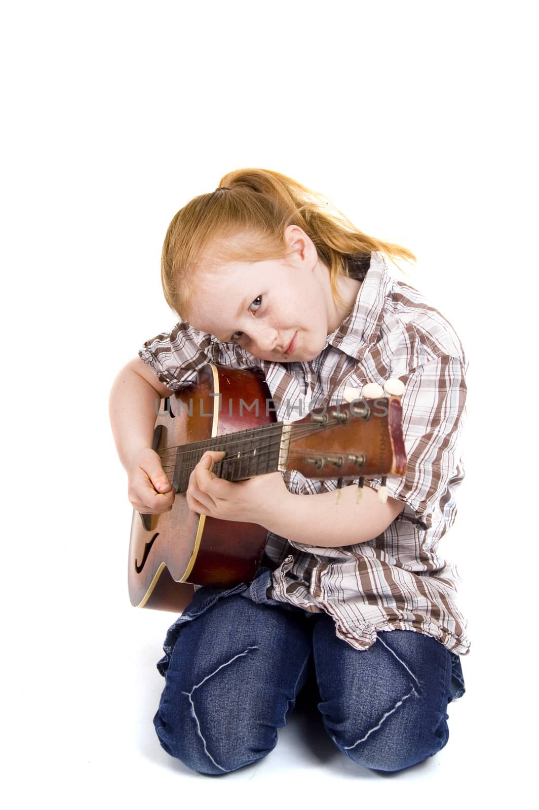 little girl playing on a guitar

