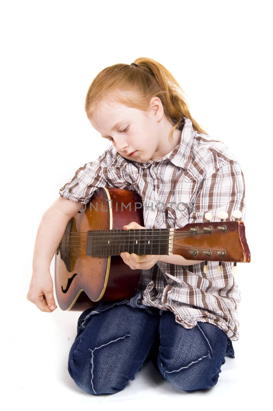little girl playing on a guitar

