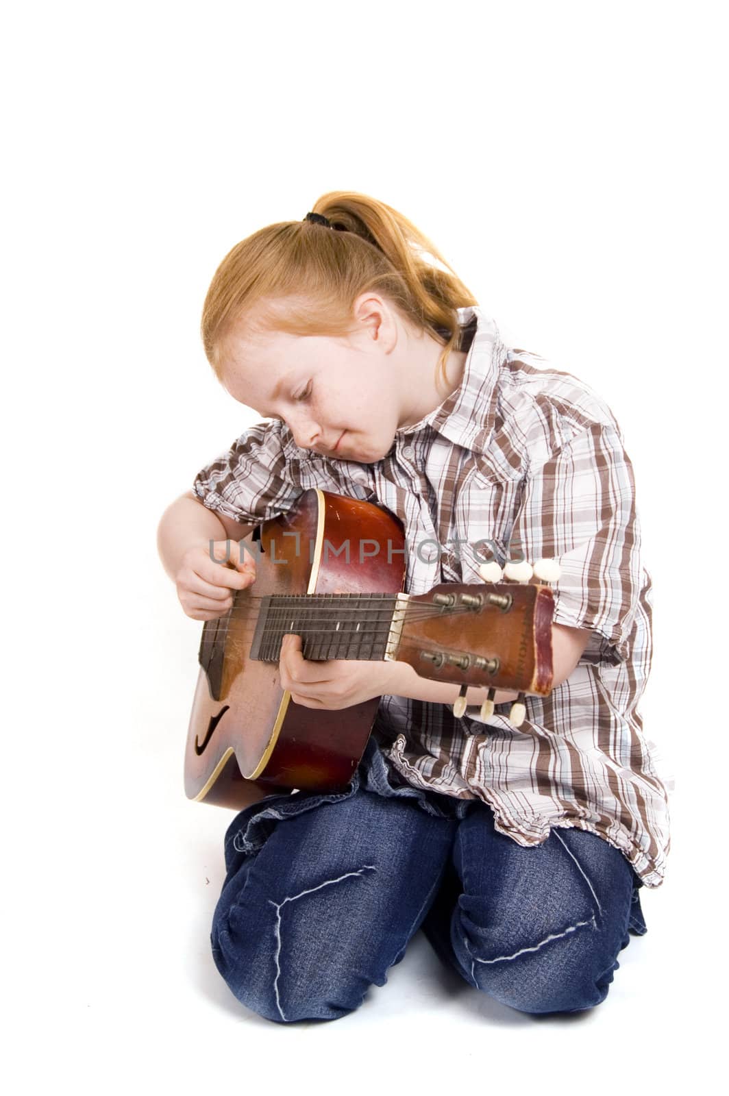 little girl playing on a guitar

