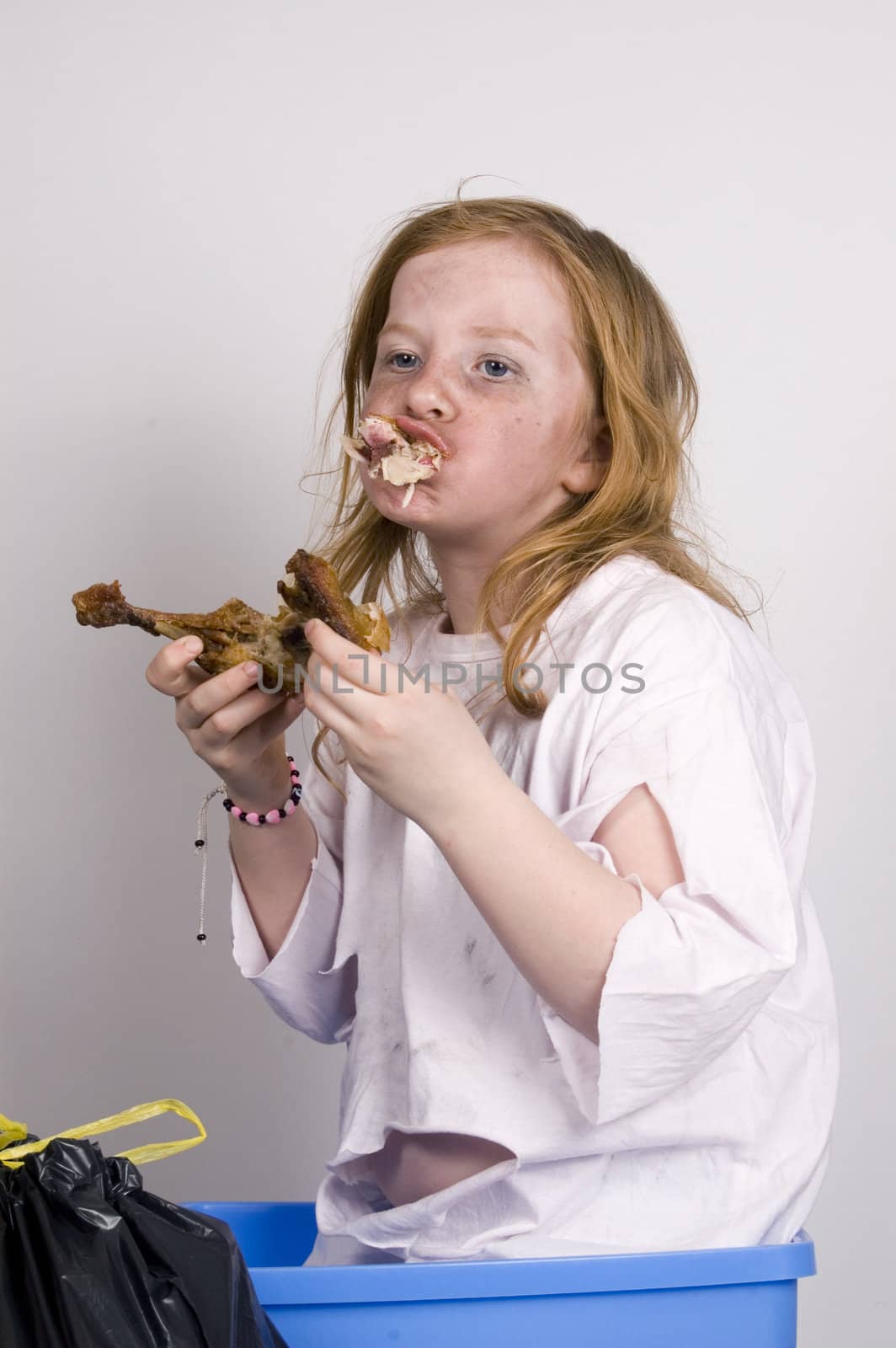 homeless girl is eating a piece of chicken