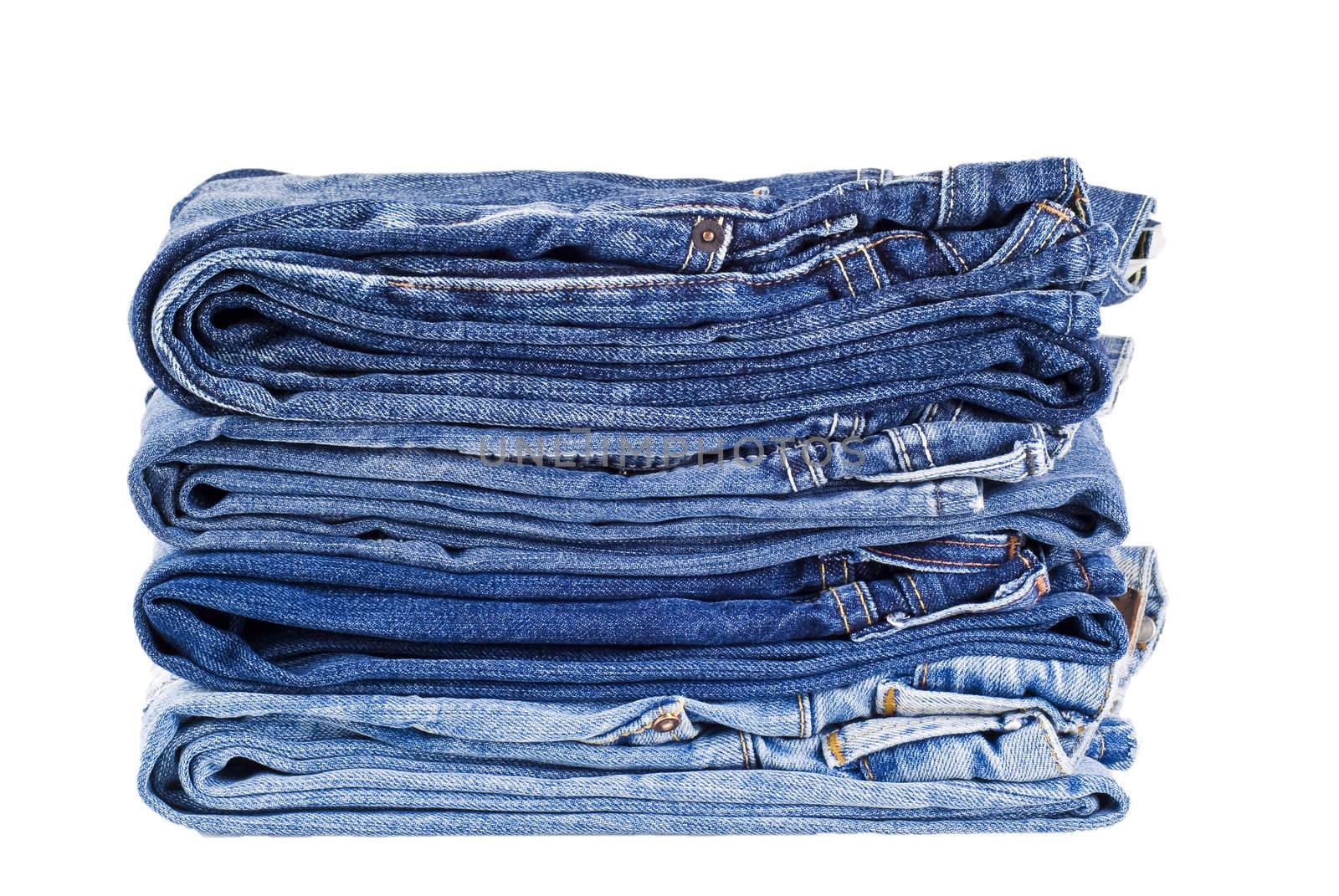Stack of four various shades blue jeans - isolated