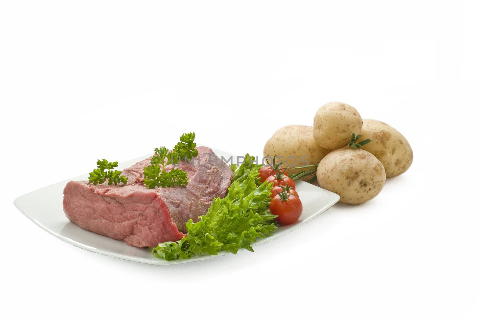 Fresh beef join with potatoes tomatoes salad and herbs