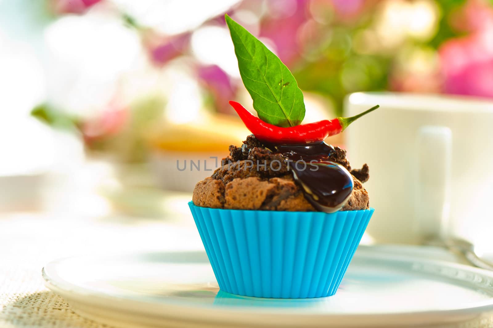 Hot chocolate cupcake with liquid chocolate and a red chili as a outdoor shooting