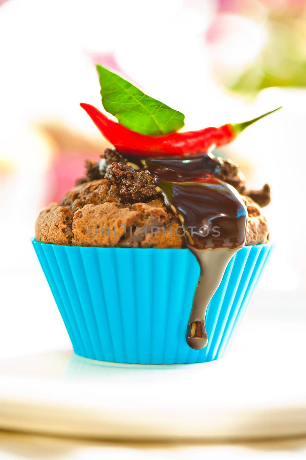 Hot chocolate cupcake with liquid chocolate and a red chili as a outdoor shooting
