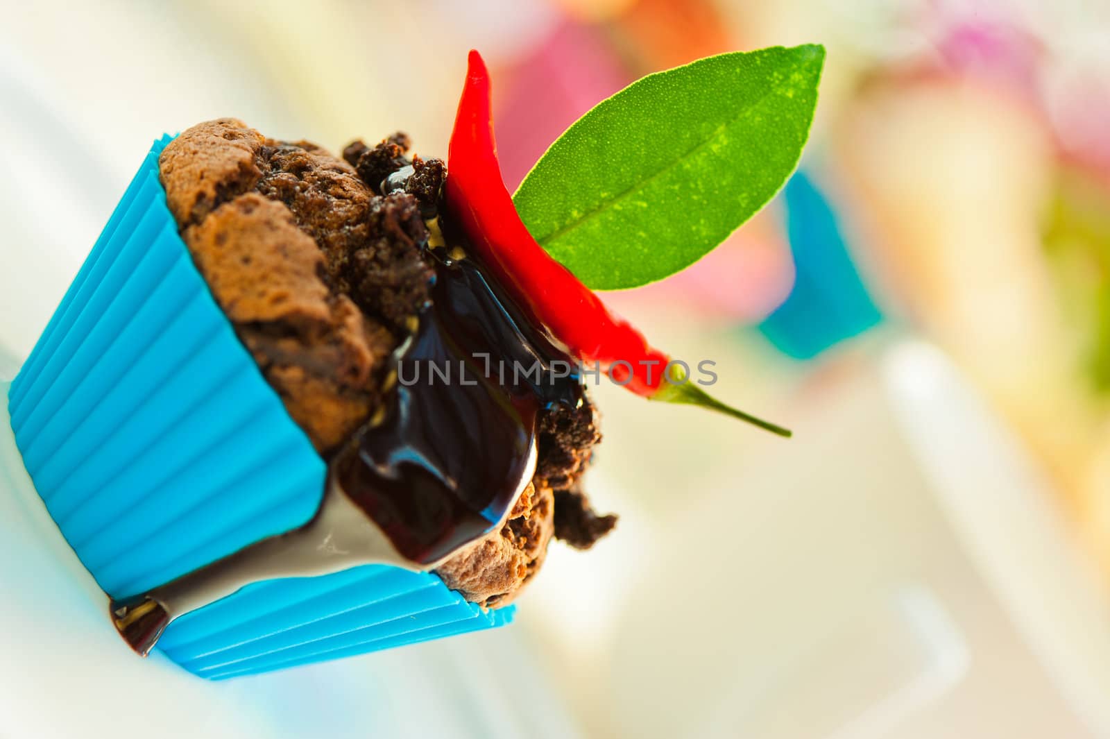 Hot chocolate cupcake with liquid chocolate and a red chili as a outdoor shooting