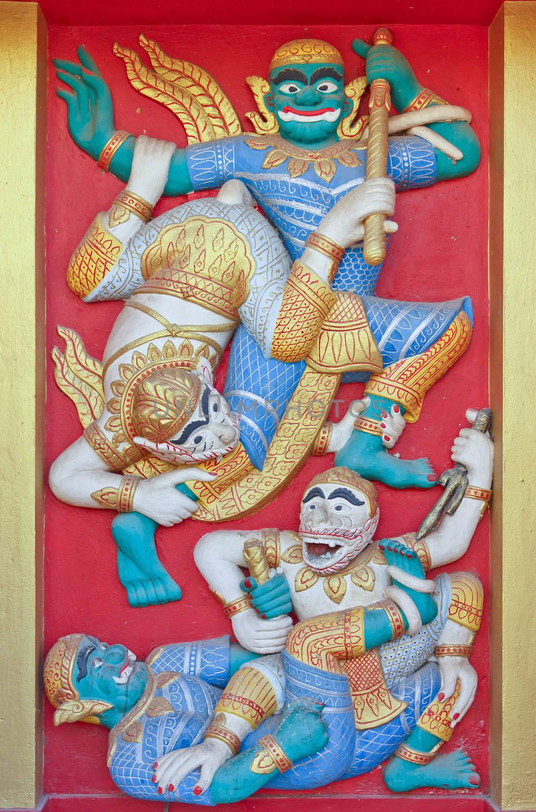 Monkey to war with demon in the Ramayana, art at temple in Laos