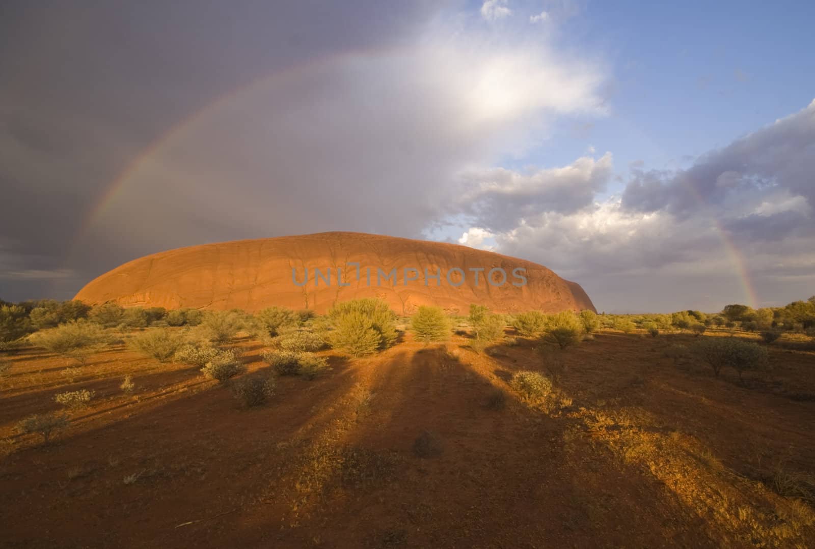 Storm clouds and rainbow over Ayers Rock (Uluru) in the Northern Territory of Australia