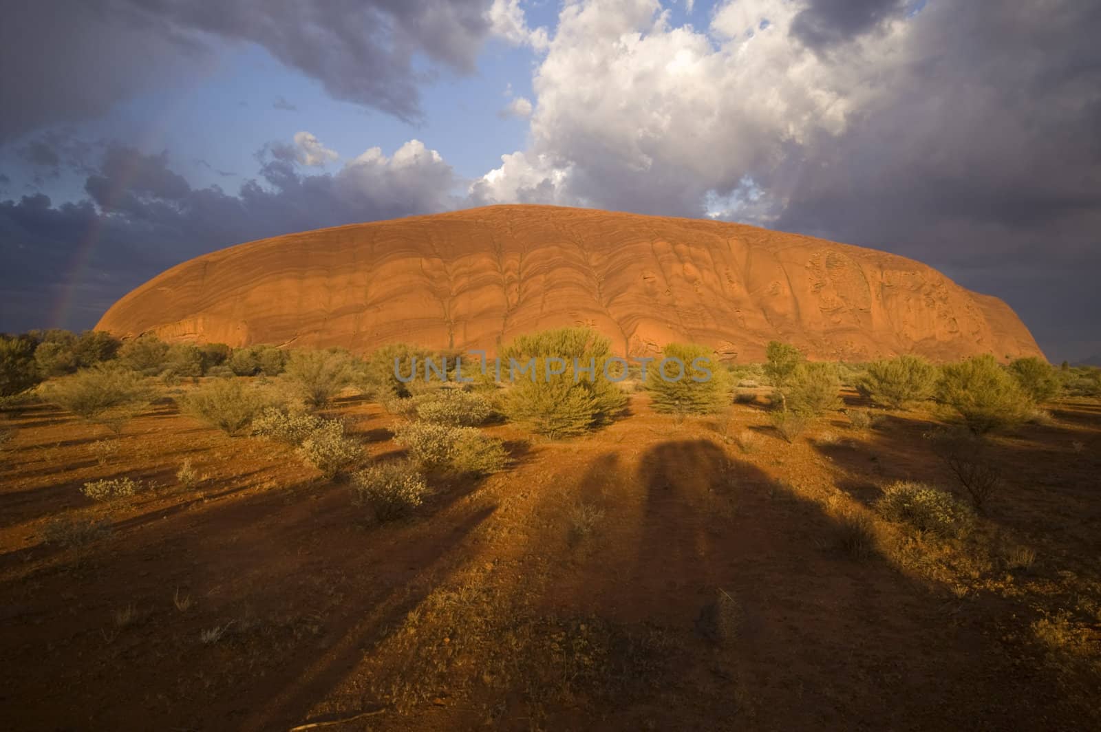 Storm clouds and rainbow over Ayers Rock (Uluru) in the Northern Territory of Australia