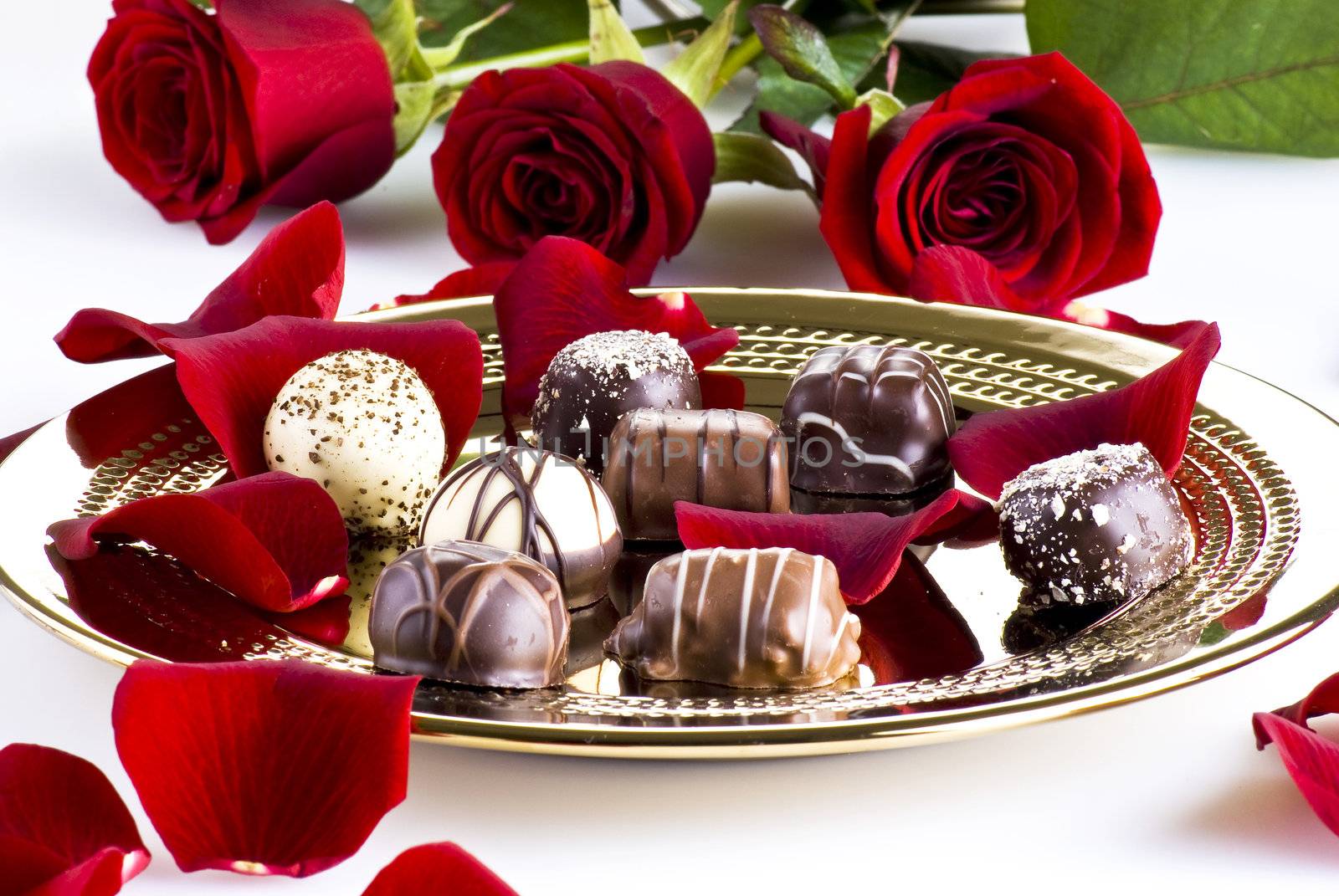 Gold plate of luxury chocolates with red roses