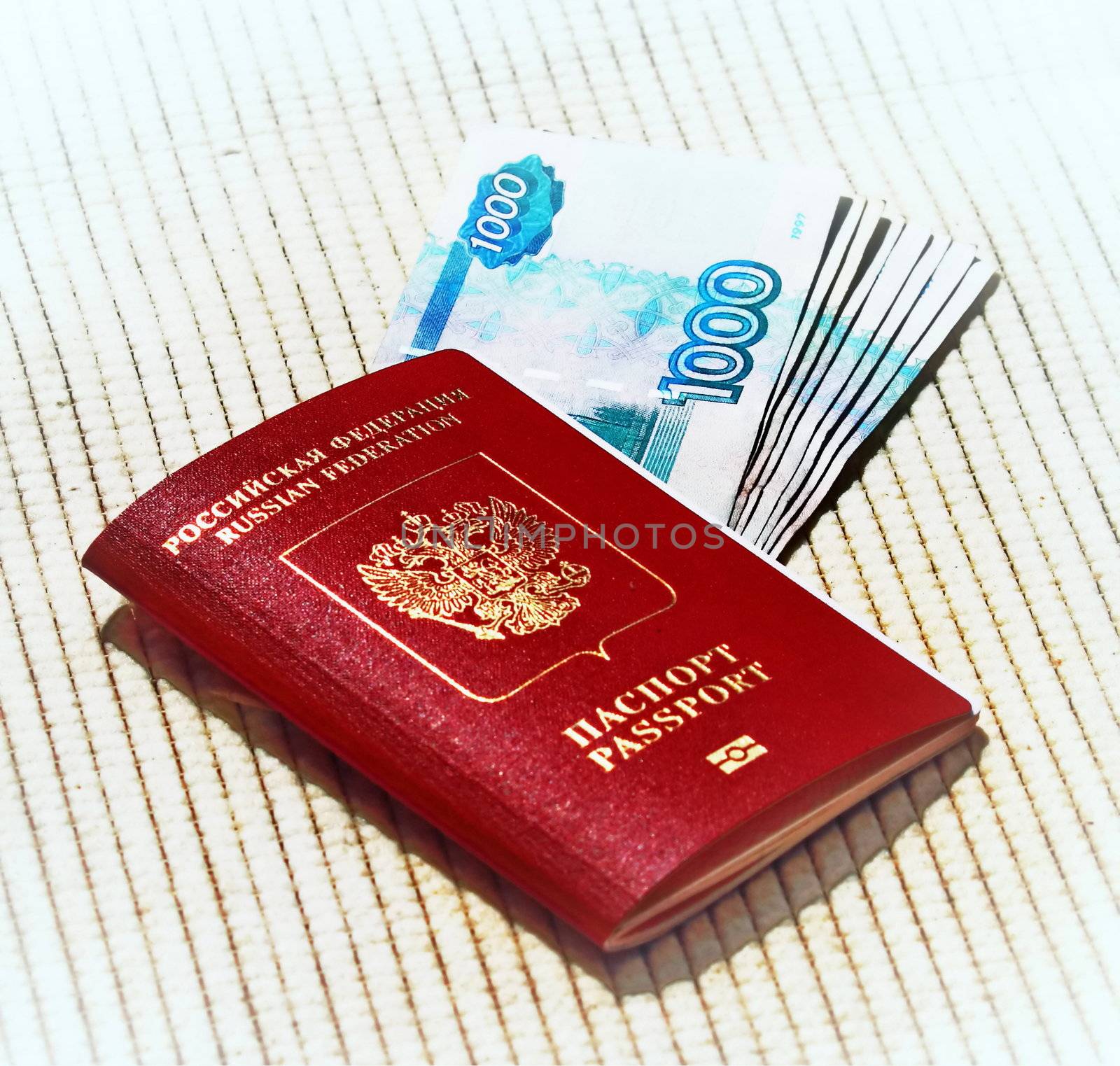 Russian passport in red with gold lettering to go abroad and rubles on a 
beige background