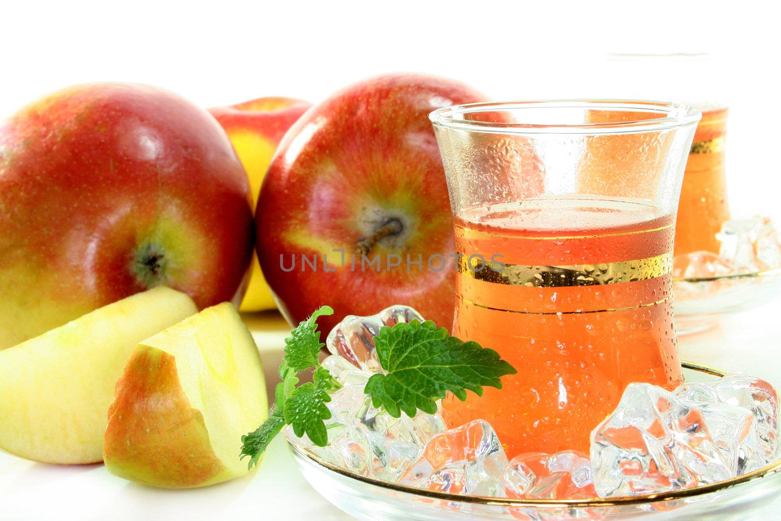 two glasses of apple ice tea with fresh apple and lemon balm