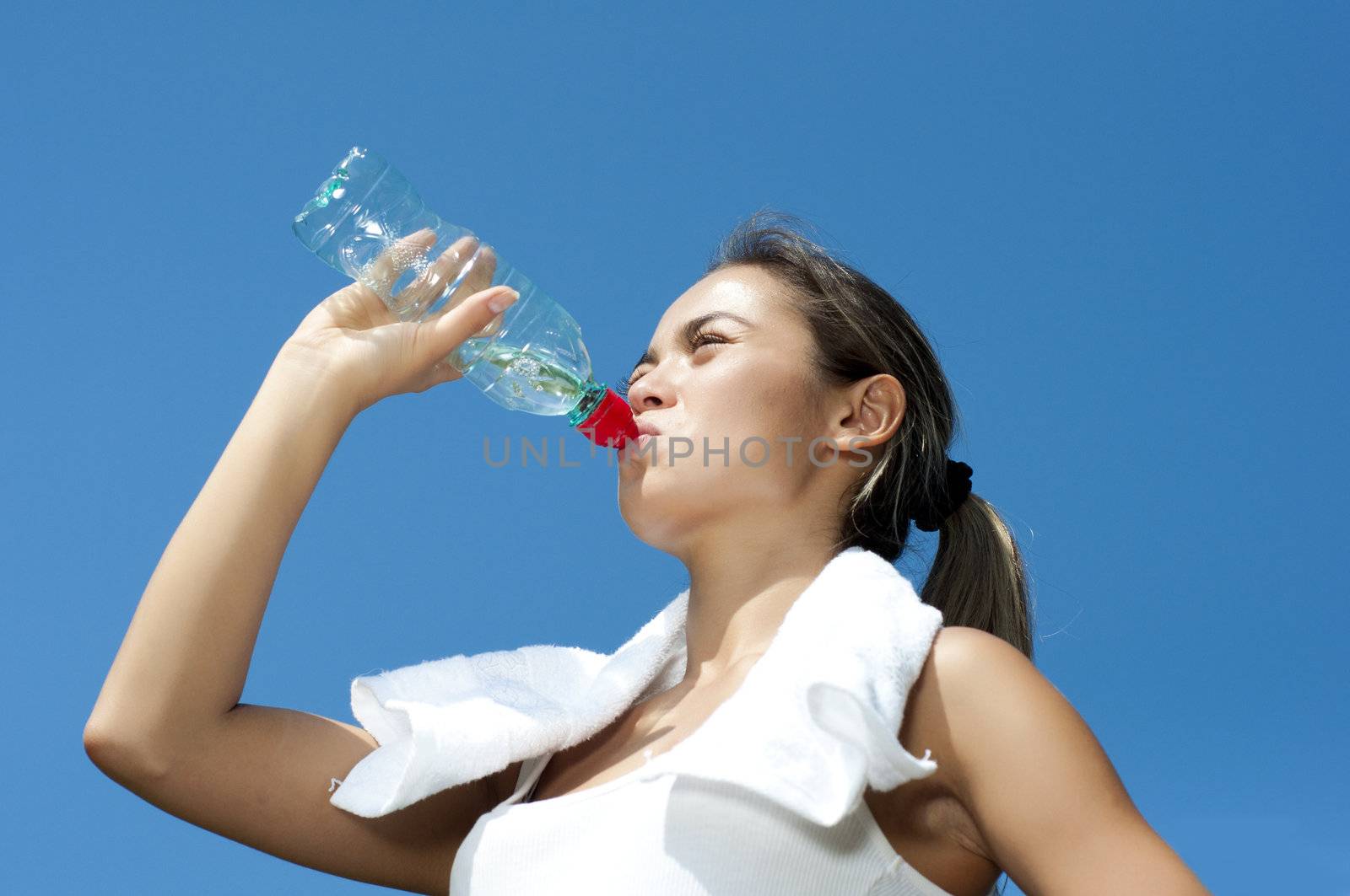 Young woman drinking water after exercise by adam121