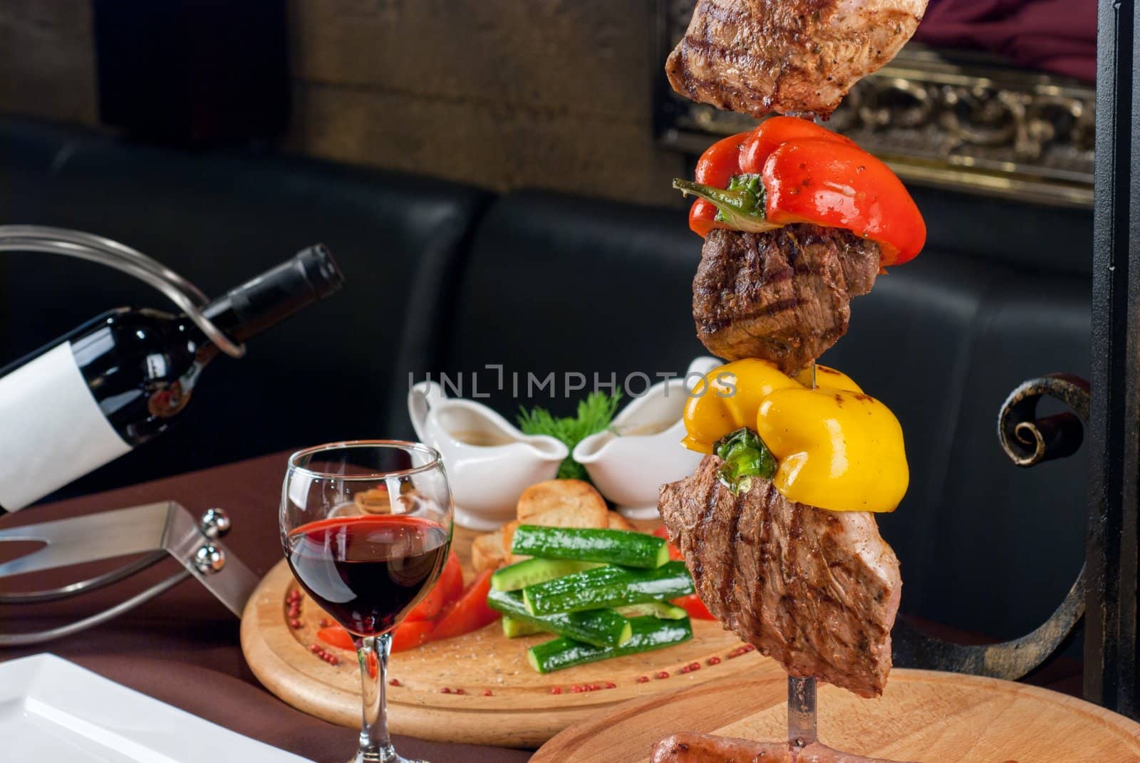 Big tasty roasted meat cuts at skewer on a decorated table