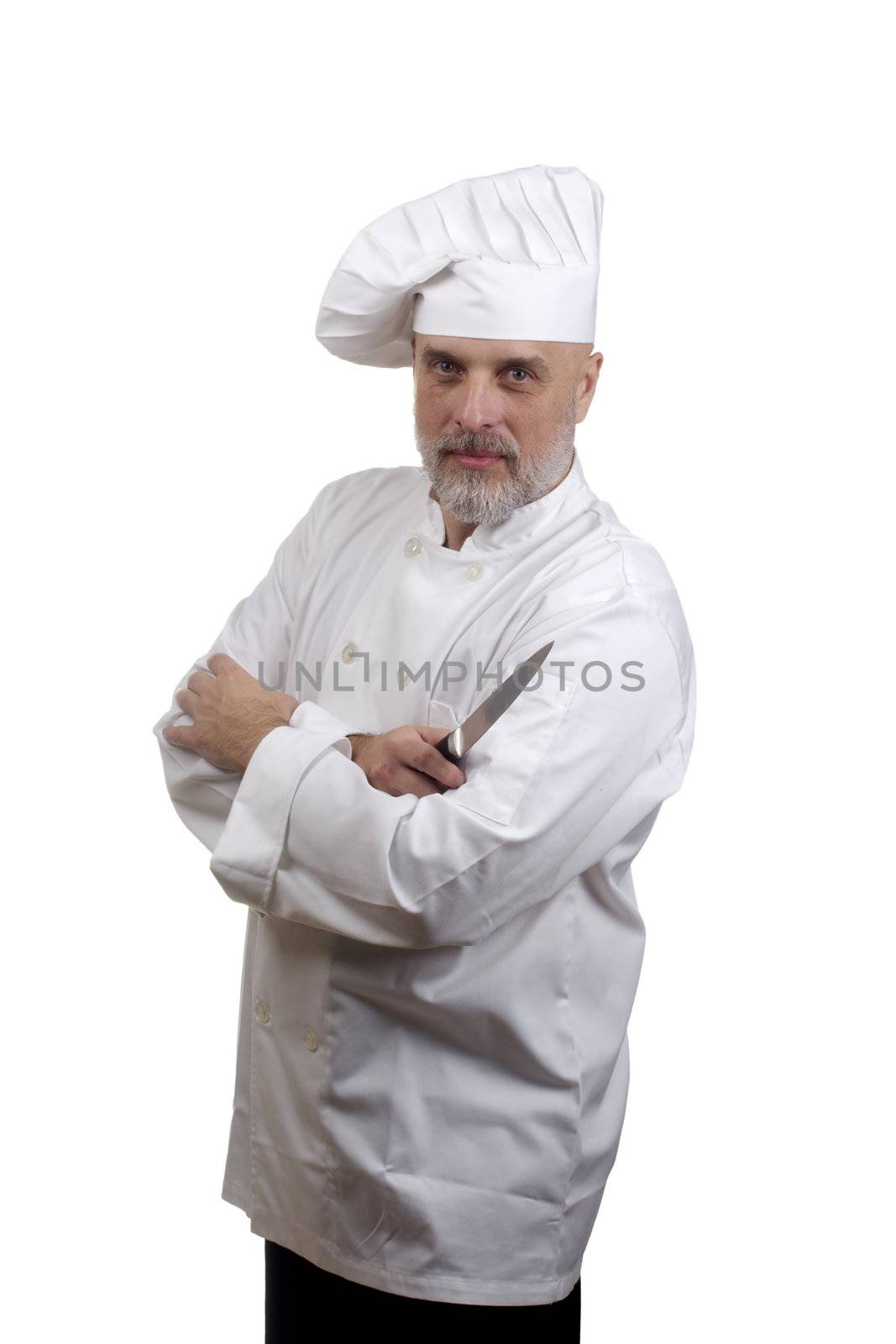 Portrait of a chef with crossed arms and a knife in a chef's hat and uniform isolated on a white background.