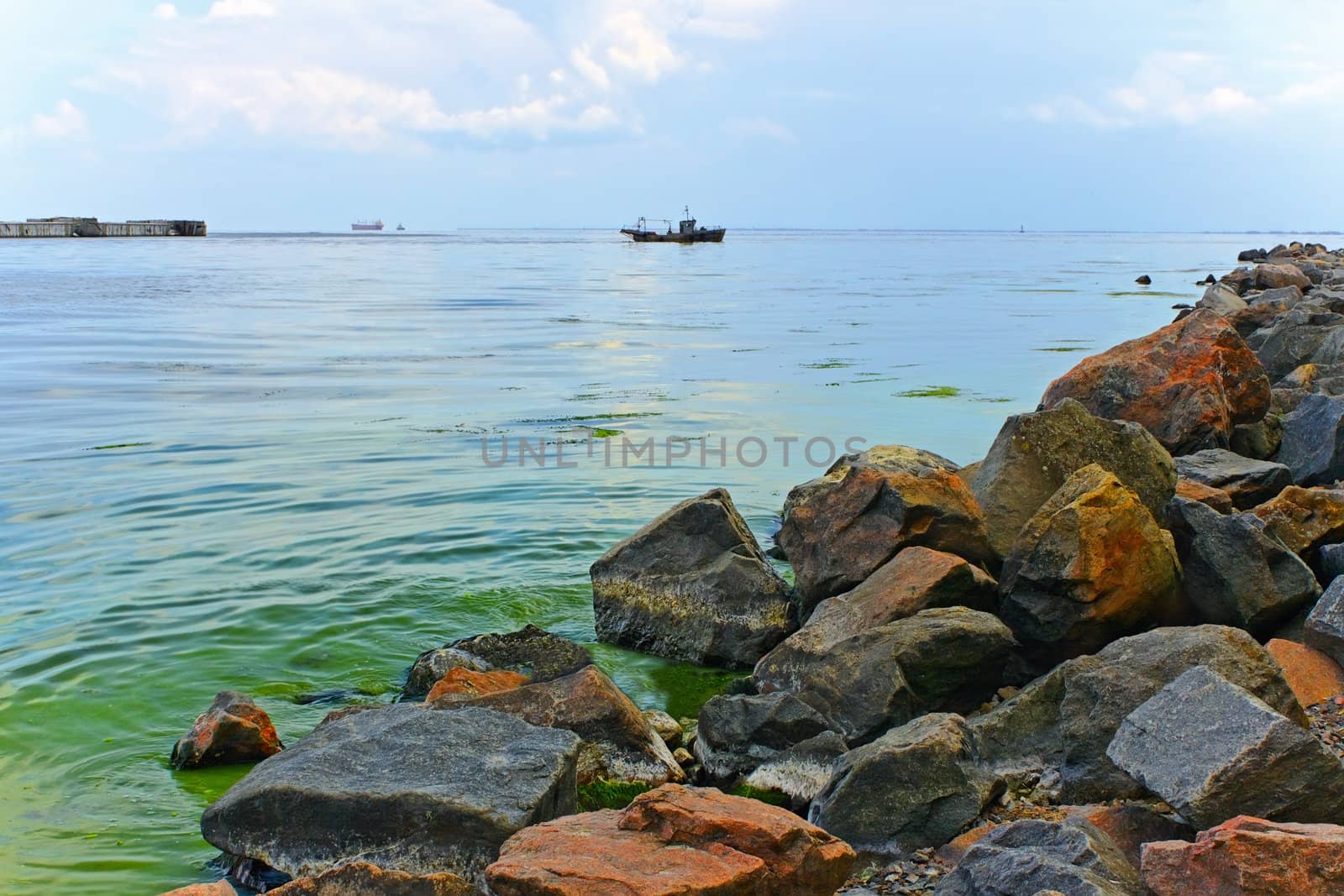 Bay with rocky shore near Ochakiv, Ukraine. Large boulders piled on the heap