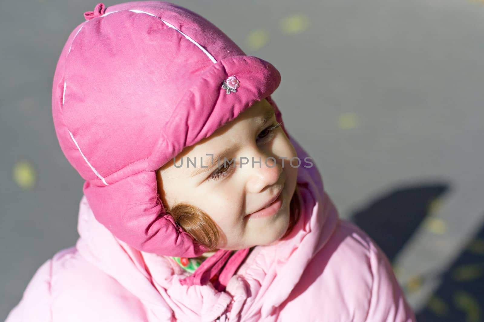 smiling little girl in a hat on the street