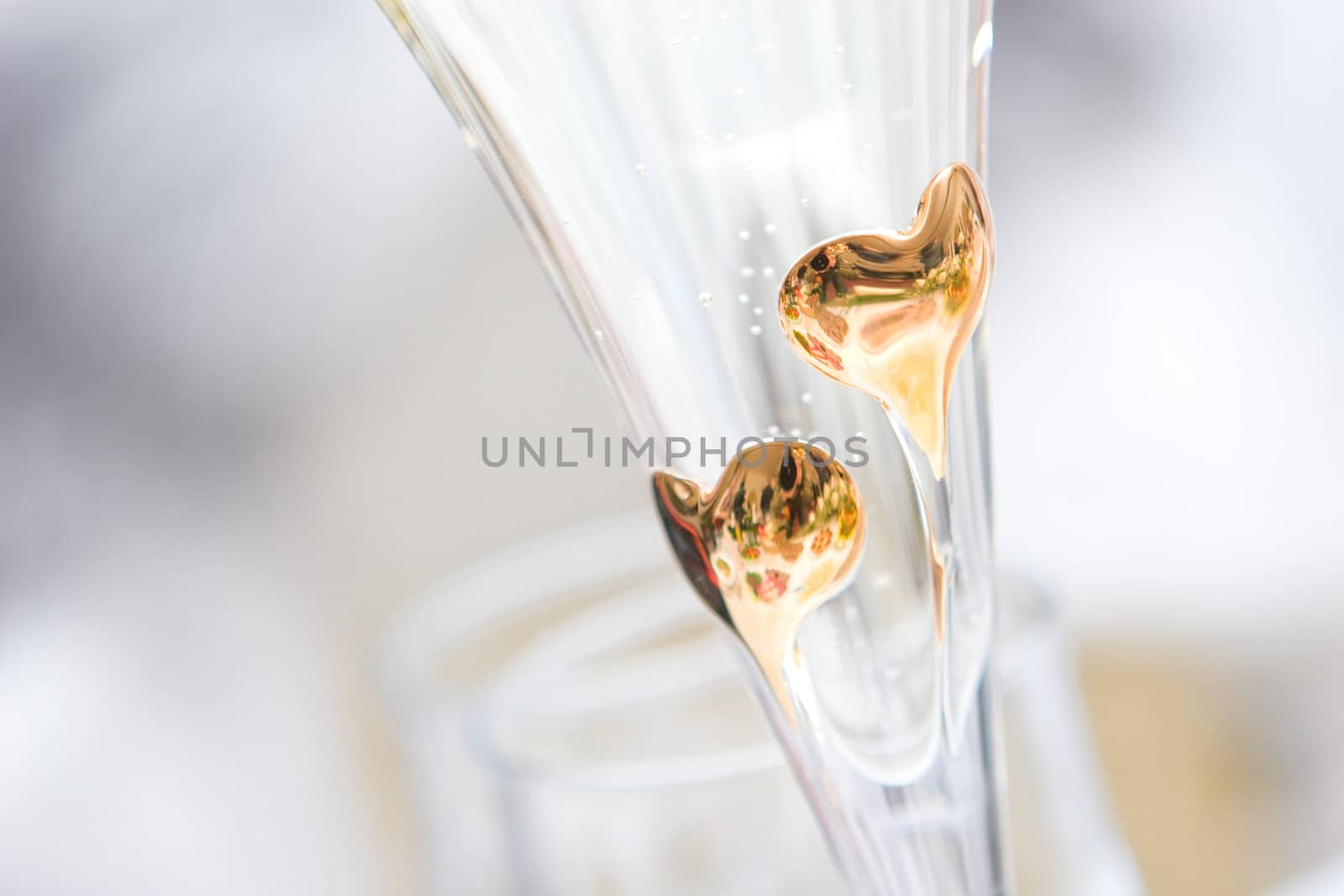 two golden hearts on the glass of champagne by vsurkov