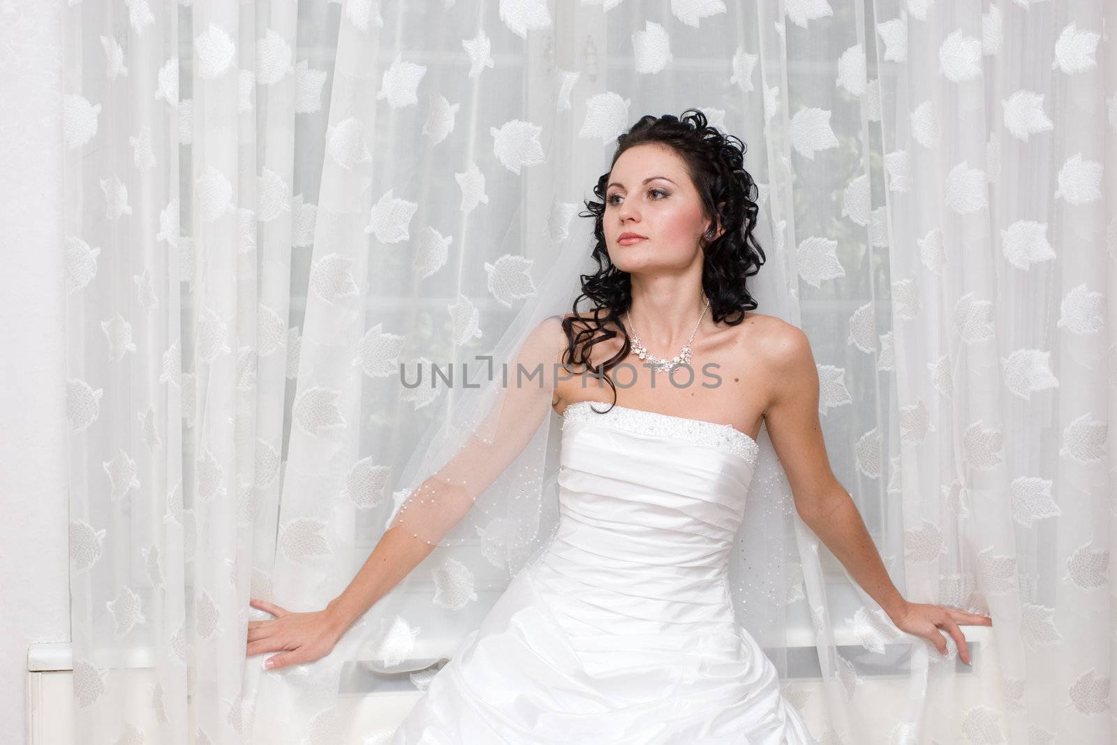 bride stands by the window