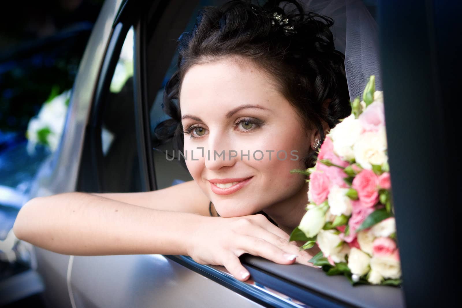 Portrait of the smiling bride sitting in the car