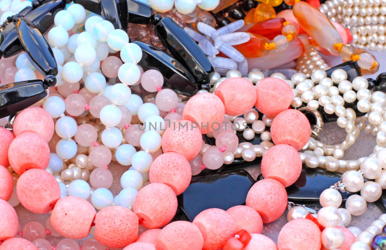 Close up of different beads made of corals, pearls and gems