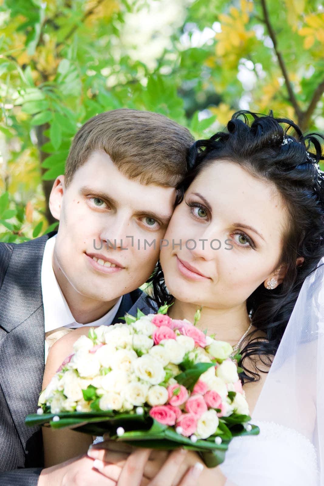 a portrait of the happy bride and groom with a flower bouquet