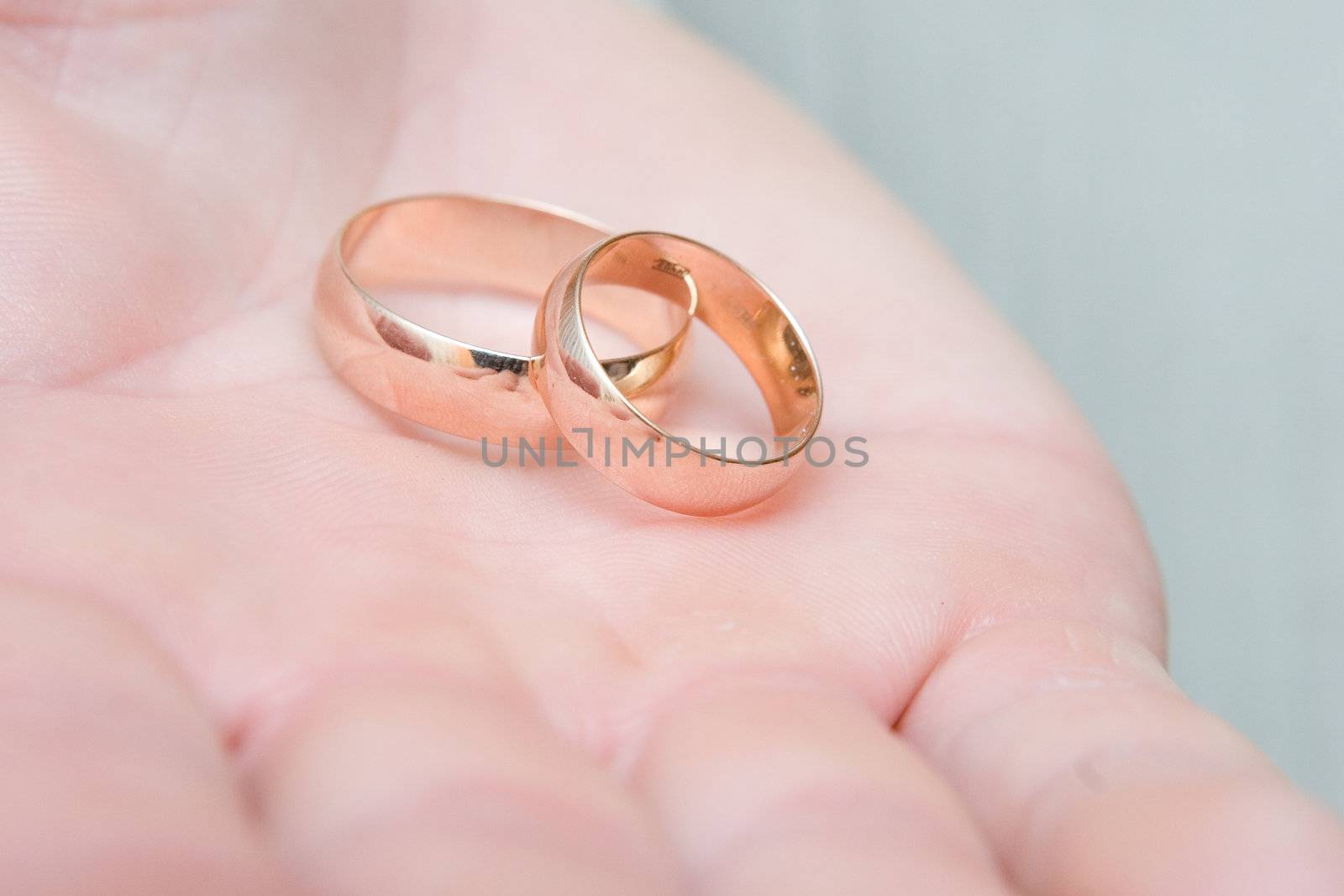gold wedding rings on a wide palm