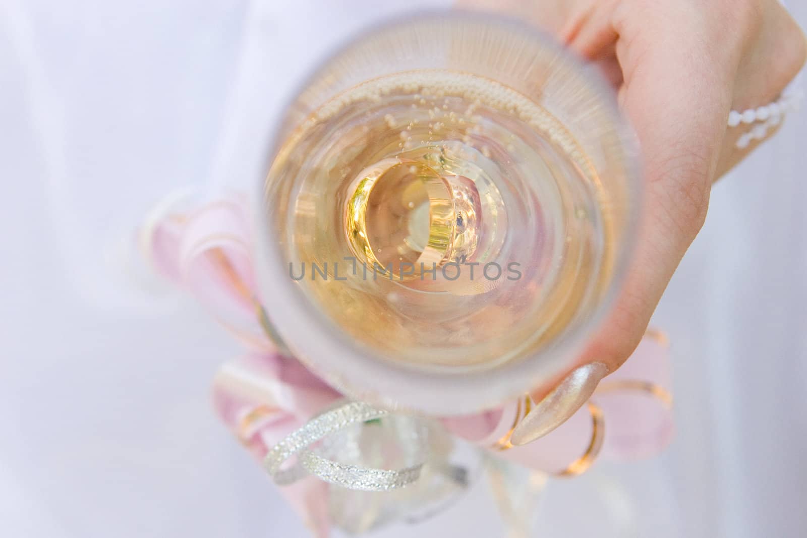 two wedding rings in a glass of champagne by vsurkov