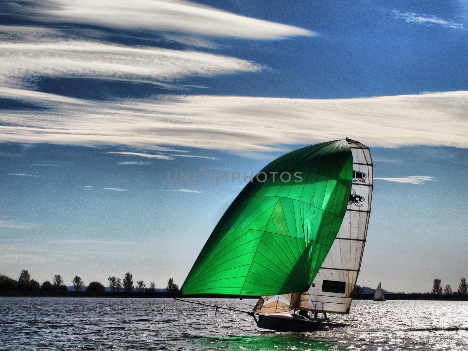 A boat with a green spinnaker sailing on Draycote Water