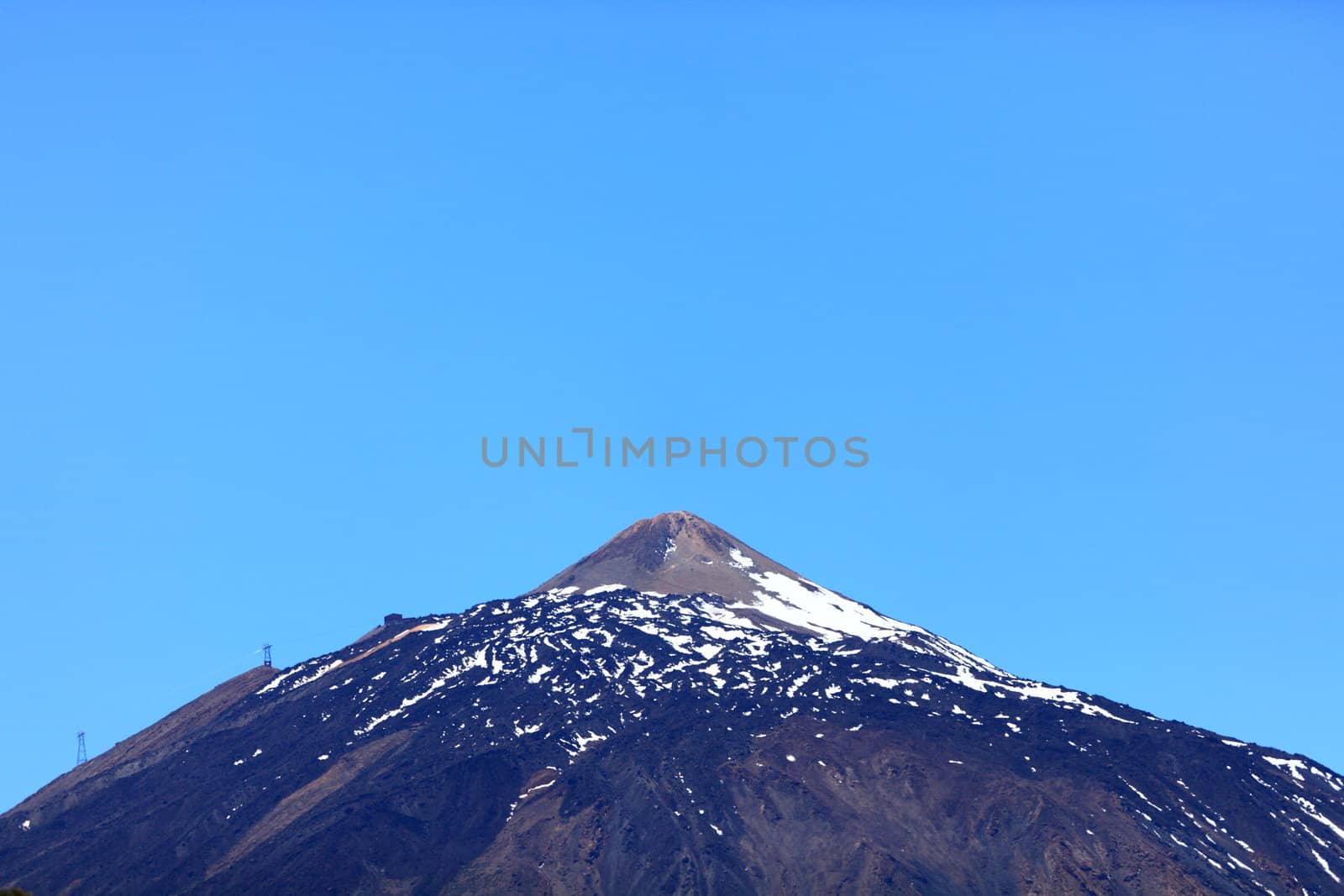 Teide mountain top. Pico del Teide - partly snow covered volcano peak photo from Tenerife during spring.