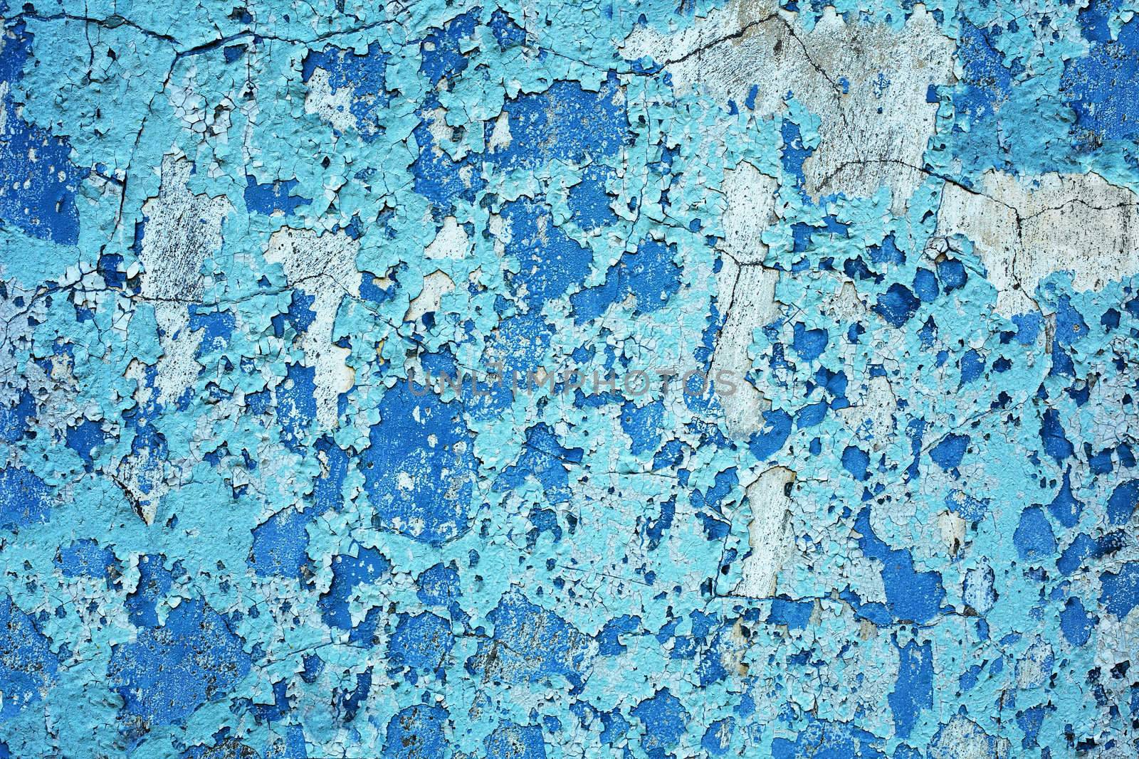 The surface of the old wall with several layers of damaged paint