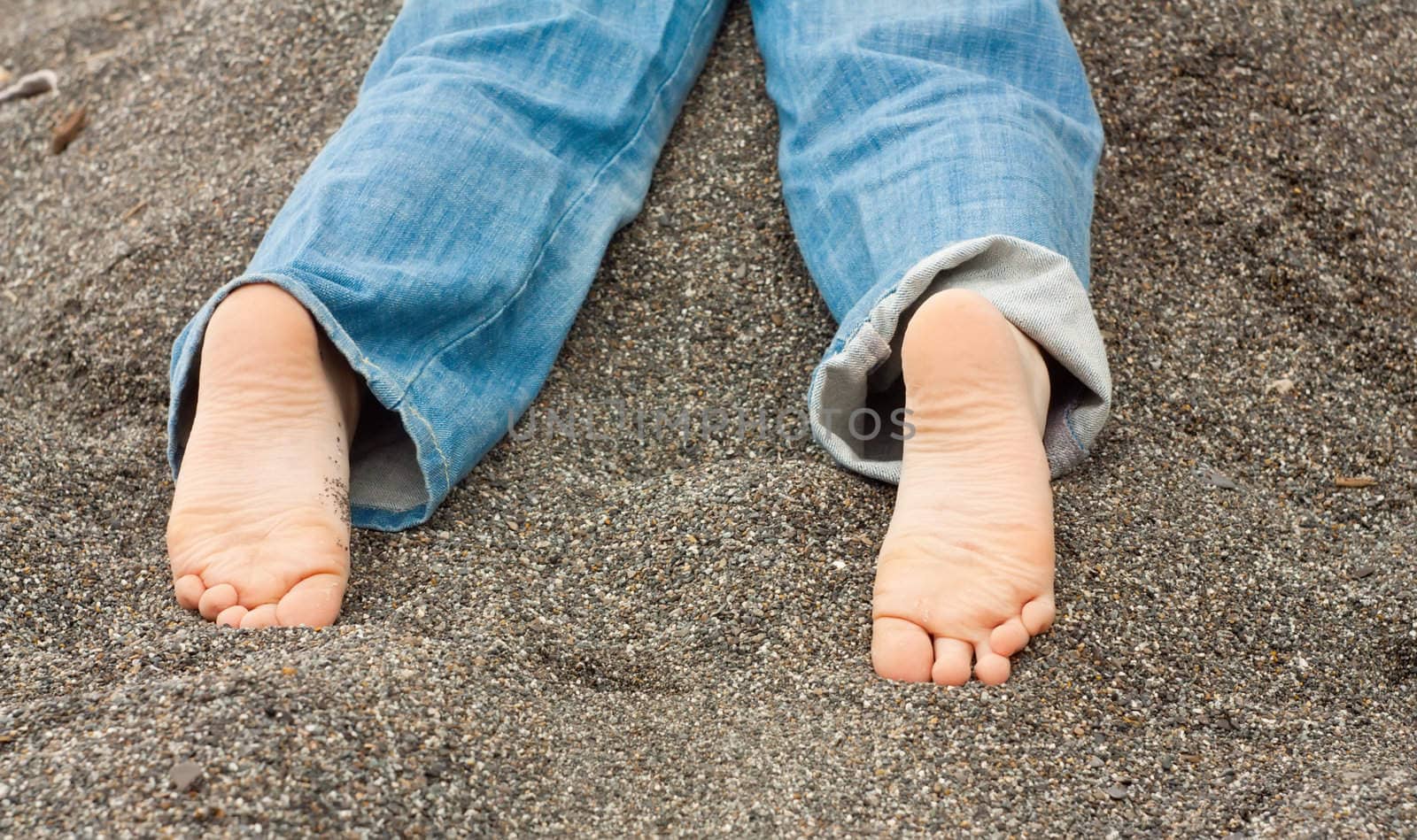 Kid feet in sand by aleksan